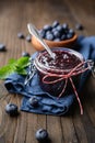 Healthy blueberry jam in a glass jar served with fresh berries