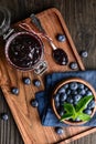 Healthy blueberry jam in a glass jar served with fresh berries