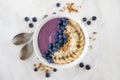 Blueberry smoothie bowl with coconut, bananas, chia seeds and granola, flat lay on marble Royalty Free Stock Photo