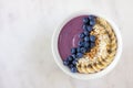 Blueberry smoothie bowl with coconut, bananas, chia seeds and granola, above view on a marble Royalty Free Stock Photo