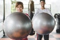 Healthy Body ball training workout. cheerful asian woman holding ball and enjoying exercise in gym with friend