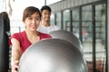 Healthy Body ball training workout. cheerful young woman holding ball and enjoying exercise in gym with friend