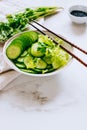 Healthy bowl, cucumber salad and coriander on marble background