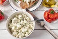 Marinated Feta cheese or sheep cheese with herbs and olive oil served for salad with roasted bread on white table Royalty Free Stock Photo