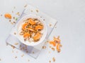 Healthy breakfast. Baked muesli with tropical fruits, fresh tangerines and yogurt on white background