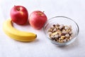 Healthy breakfast with banana, apple and Fresh granola, muesli in bowl on textile background. Top view. Royalty Free Stock Photo