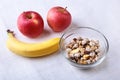 Healthy breakfast with banana, apple and Fresh granola, muesli in bowl on textile background. Top view. Royalty Free Stock Photo