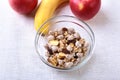 Healthy breakfast with banana, apple and Fresh granola, muesli in bowl on textile background. Top view. Royalty Free Stock Photo