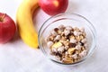 Healthy breakfast with banana, apple and Fresh granola, muesli in bowl on textile background. Top view. Royalty Free Stock Photo