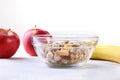 Healthy breakfast with banana, apple and Fresh granola, muesli in bowl on textile background. Top view. Royalty Free Stock Photo