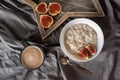 Healthy breakfast in bed. Coffee, porridge with figs, on a rustic wooden board. Clean food, alkaline diet,