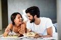 Healthy breakfast in bed. Young beautiful couple in love is sitting on bed and having breakfast. Royalty Free Stock Photo