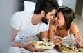 Healthy breakfast in bed. Young beautiful couple in love is sitting on bed and having breakfast. Royalty Free Stock Photo