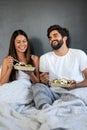 Healthy breakfast in bed. Young beautiful couple in love is sitting on bed and having breakfast. Royalty Free Stock Photo