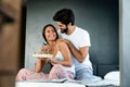 Healthy breakfast in bed. Young beautiful couple in love is sitting on bed and having breakfast. Royalty Free Stock Photo