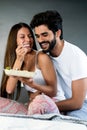 Healthy breakfast in bed. Young beautiful couple in love is sitting on bed and having breakfast. Royalty Free Stock Photo