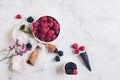 Healthy breakfast. Blackberries and raspberries, waffle ice cream cone and flowers on white marble background Royalty Free Stock Photo