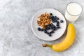Healthy breakfast, blueberry, walnut, banana, glass of milk on cement background. healthy food. Proper nutrition