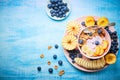 Healthy breakfast bowl berry greek yoghurt with frefh blueberries, banana and flakes on the blue wooden table Royalty Free Stock Photo