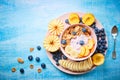 Healthy breakfast bowl berry greek yoghurt with frefh blueberries, banana and flakes on the blue wooden table Royalty Free Stock Photo