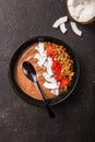 Healthy breakfast bowl. Chocolate banana smoothie bowl with coconut flakes, granola, strawberry. Top view, flat lay, overhead