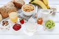 Healthy breakfast: bowl of corn flakes, jug of milk, sliced fruits, jar of honey Royalty Free Stock Photo