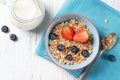 Healthy breakfast, bowl with granola muesli with strawberry and blueberry and milk jug, wooden background, top view Royalty Free Stock Photo