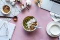 Healthy breakfast bowl milk laptop organizer on pink table background concept