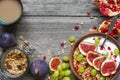 Healthy breakfast. bowl of oat granola with yogurt, pomegranate seeds, figs, grape and nuts with a spoon and cappuccino Royalty Free Stock Photo