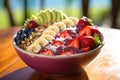 Healthy breakfast bowl with oatmeal, fresh berries and fruits on wooden table, A delicious, colorful acai bowl on a warm sunny day