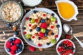 Healthy breakfast. bowl of oatmeal porridge with berries, nuts, honey and glass of milk on rustic wooden table Royalty Free Stock Photo