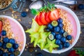 Healthy breakfast bowl: raspberry smoothies with granola, blueberries, strawberries and carambola