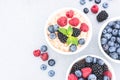 Healthy breakfast - bowls with oatmeal porridge served with various berries on concrete table background with copy space