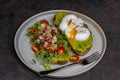 Healthy breakfast with bread toast and poached egg with green salad, red tomato and smashed avocado Royalty Free Stock Photo