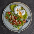 Healthy breakfast with bread toast and poached egg with green salad, red tomato and smashed avocado Royalty Free Stock Photo