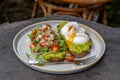 Healthy breakfast with bread toast and poached egg with green salad, red tomato and smashed avocado Royalty Free Stock Photo