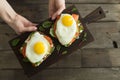 Healthy breakfast. Bread toasts with cheese, fried eggs, fish and fresh vegetables over wooden background, top view. Diet, weight Royalty Free Stock Photo