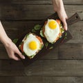 Healthy breakfast. Bread toasts with cheese, fried eggs, fish and fresh vegetables over wooden background, top view. Diet, weight Royalty Free Stock Photo