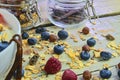 Healthy breakfast, cereal with yoghurt, strawberries, blueberries, raspberries and muesli on wooden rustic background Royalty Free Stock Photo