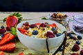 Healthy breakfast, cereal with yoghurt, strawberries, blueberries, raspberries and muesli on wooden rustic background Royalty Free Stock Photo