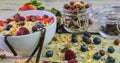 Healthy breakfast, cereal with yoghurt, strawberries, blueberries, raspberries and muesli on wooden rustic background Royalty Free Stock Photo