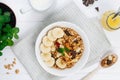 Healthy breakfast with chocolate granola in the bowl with banana and nuts on the table