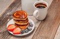 Healthy breakfast. Coffee and delicious pancakes, with fresh berries on wooden table Royalty Free Stock Photo