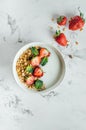 Healthy breakfast concept. Bowl with granola, yogurt and berries on white marble background Royalty Free Stock Photo