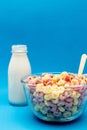 Healthy breakfast concept, Colorful ring cereals in glass bowl and milk on light blue background Royalty Free Stock Photo