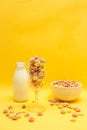 Healthy breakfast concept, Colorful ring cereals in glass and bowl with milk on yellow background Royalty Free Stock Photo