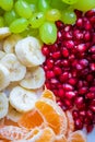 Healthy Breakfast Concept. Fresh fruits on the breakfast table. Close up of Grapes, banana, oranges, pomegranate.
