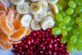 Healthy Breakfast Concept. Fresh fruits on the breakfast table. Close up of Grapes, banana, oranges, pomegranate.