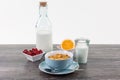 Healthy breakfast with cornflakes, milk, orange fruit on a wooden table Royalty Free Stock Photo