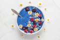 Healthy breakfast dessert. blue spirulina smoothie bowl with fresh and frozen berries, coconut and chamomile flowers Royalty Free Stock Photo